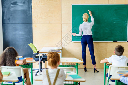 学生在黑板上写字时看着老师的后视图图片