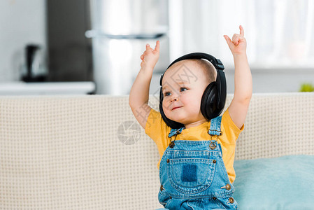 在耳机中可爱的男小孩听音乐在家里图片