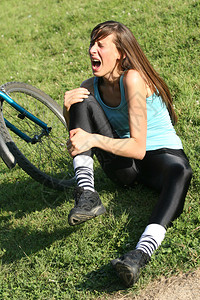 骑脚踏车的女骑自行车者摔了一跤图片