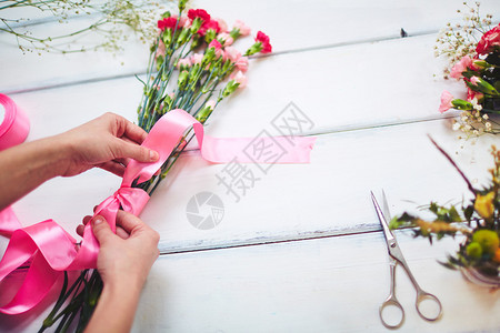 佛花手把康乃馨花束和粉色丝带绑图片