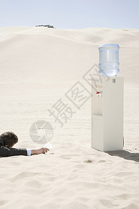 沙漠中饮水机旁的人图片