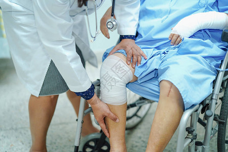 医生在轮椅上用绷带检查膝盖图片