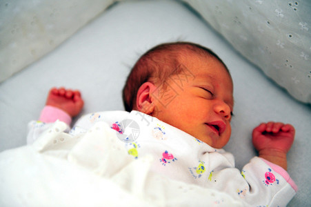 一个刚出生的婴儿睡在婴儿床上图片