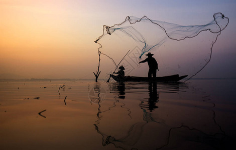 在泰国湖边钓鱼的渔夫船上的渔图片