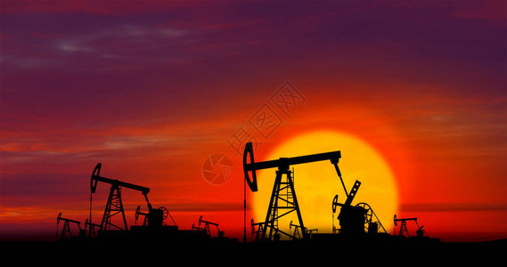 工作在云彩和太阳的油泵剪影在背景中日落时油田上的抽油机石油钻井平台全球变暖环境污染和化背景图片