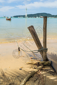 一条船的绳子用木桩绑在海滩上图片
