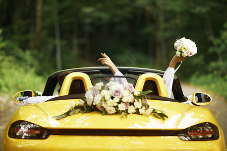 新婚夫妇与婚车敞篷车后视图背景图片