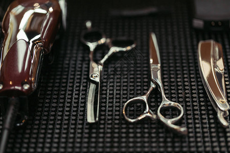 理发店剪刀电动理发器和直剃须刀的特写视图图片