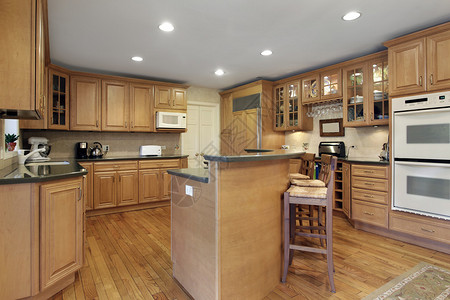 带橡木橱柜和双层岛台的厨房图片