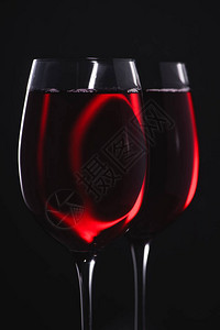 黑色上装满红酒的眼镜的特写镜头图片