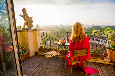日出时坐在阳台上的女人图片
