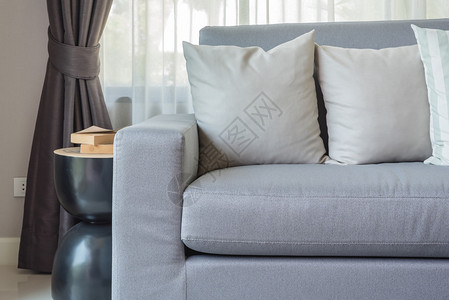 家里客厅里带枕头的现代灰色沙发图片