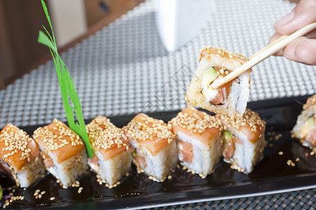 用筷子吃豪华寿司的人手背景图片