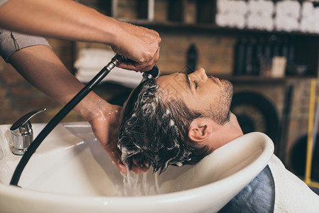 发型师在理发店给客户洗头发图片