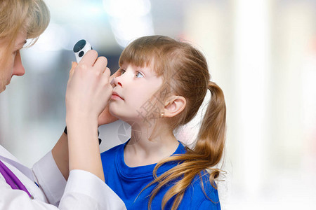 女眼科医生在病房背景下用特殊设备检查小孩眼睛的特写眼部问图片