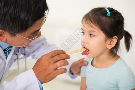 医生用压舌板检查女孩的喉咙图片