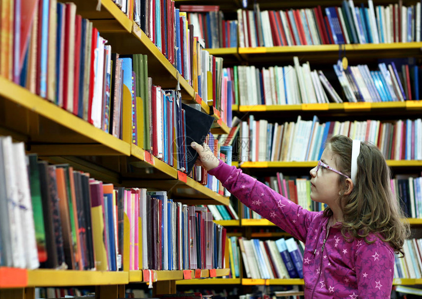 小女孩在图书馆拿书图片