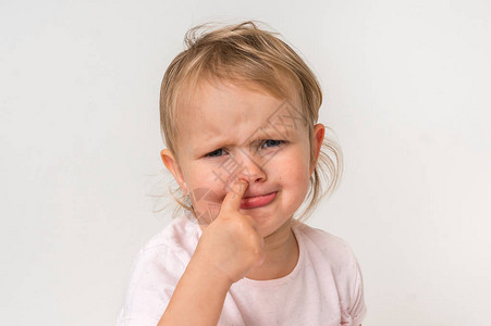 可悲的女婴用内指抽鼻子卫生概念伤痛的背景图片