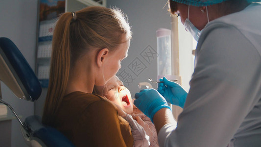女孩她的母亲和牙医办公室的牙医图片
