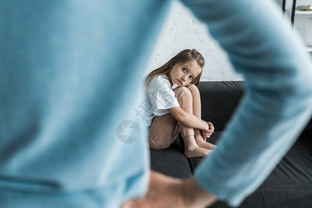坐在沙发上看着母亲用手站在站着的惊吓儿童有选择图片