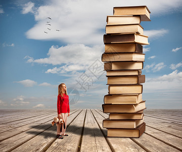 那个小女孩和一堆蓝天背景的书背景图片