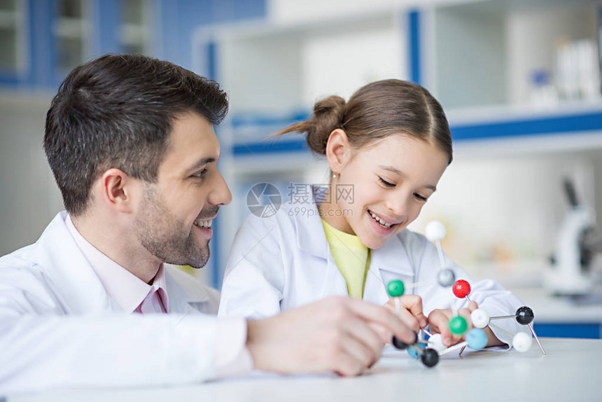 微笑的教师和学生科学家在实验图片