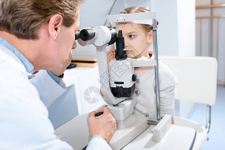 眼科医生检查在诊所用断线灯切开灯的幼龄图片