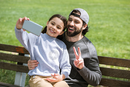 女儿和父亲在公园做和平姿图片