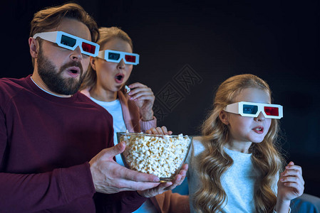 3D眼镜的惊吓家庭看电影和吃爆米花图片