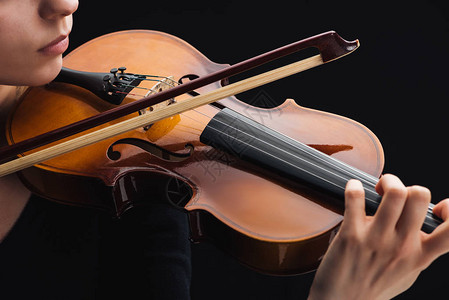 女人用黑色隔离的弓演奏大提琴的剪影高清图片