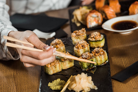 妇女用筷子吃寿司卷的部分看法图片