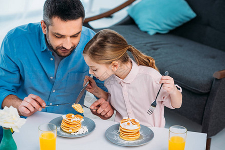 父亲和小女儿在家吃早饭孩子的图片