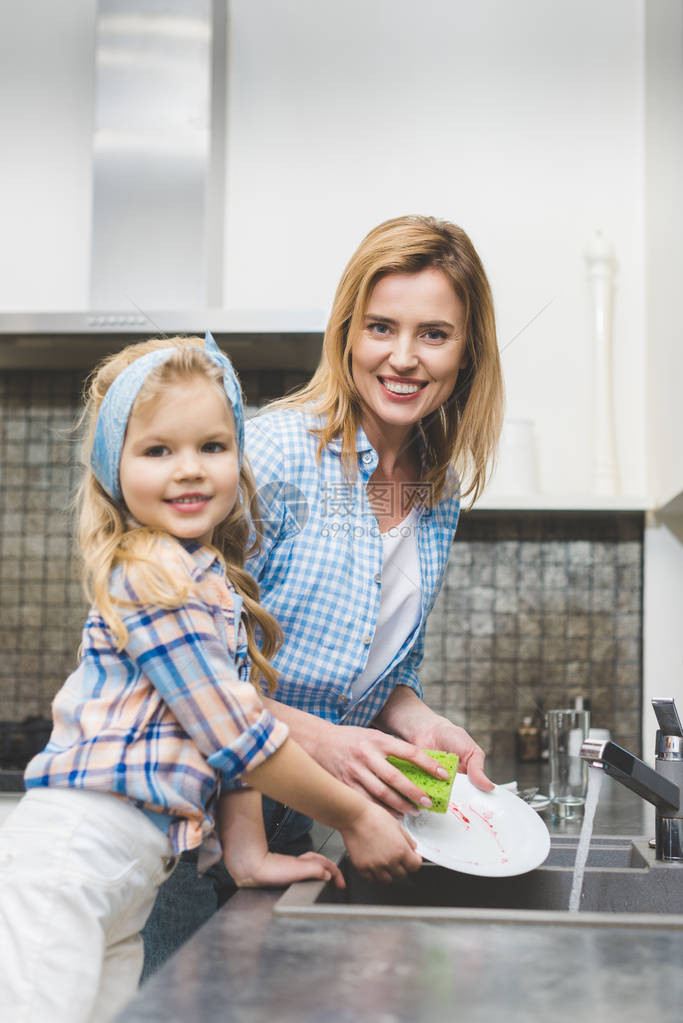 小女儿和小母亲在厨房一起吃晚饭后一起洗盘子时图片