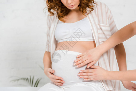 按摩中心按摩台为怀孕女孩做腹部按摩的按摩图片