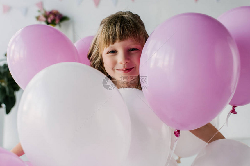 微笑可爱的孩子站在气球上的肖像图片
