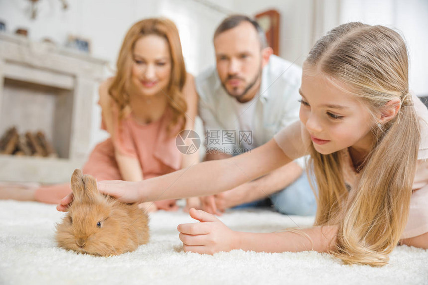 家庭快乐一个孩子在家玩可爱的毛发兔图片