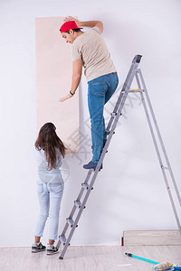 年轻家庭在家里用新墙背景图片