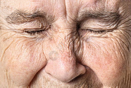 面部皱纹的老脸贴近了一个闭着眼睛的高清图片