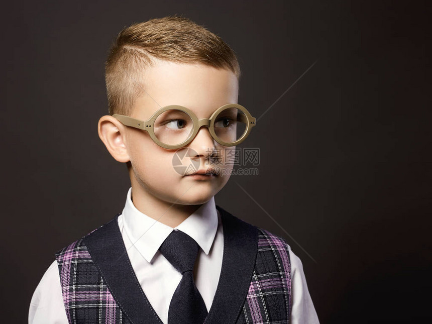 身戴眼镜的小男孩站在校董会旁边