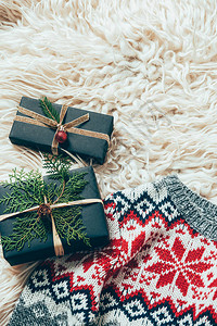 包着的圣诞节礼物和冬毛衣在羊毛背景图片