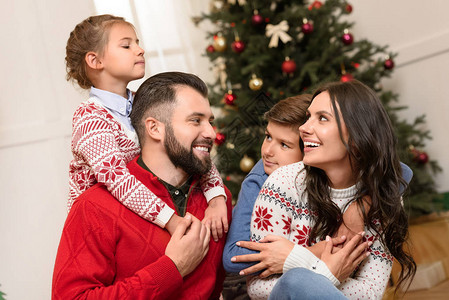 有两个孩子的幸福家庭在圣诞节拥抱和微图片