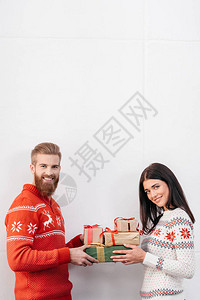 快乐的一对年轻夫妻拿着圣诞礼物背景图片