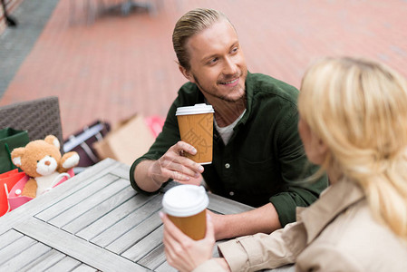 年轻男子在咖啡馆喝可支配咖啡时与女友聊天图片