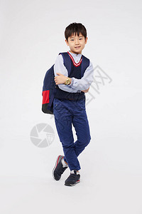 自信的小男孩穿着校服背着包图片