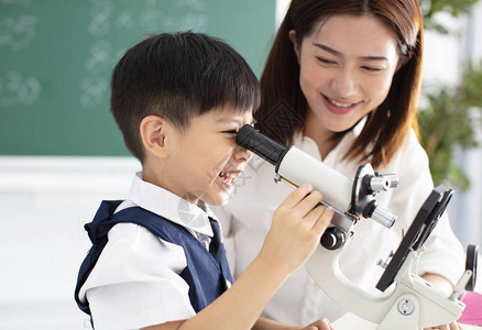 老师帮助孩子用显微镜做实验图片
