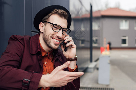 在智能手机上交谈的快乐时尚男人图片