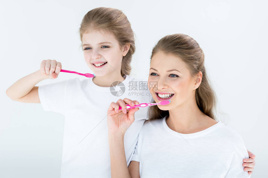 快乐的母女用白色牙刷清洁牙齿图片