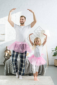 快乐的父亲和可爱的小女儿穿着粉红色的Ttutu裙子跳舞图片