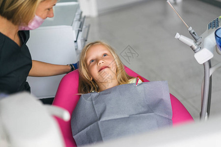 以医疗面罩和在牙医办公室的椅子上笑着孩子的口腔图片