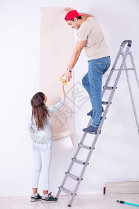 年轻家庭在家里用新墙背景图片